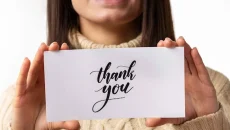 up close of a girl holding a thank you note up close